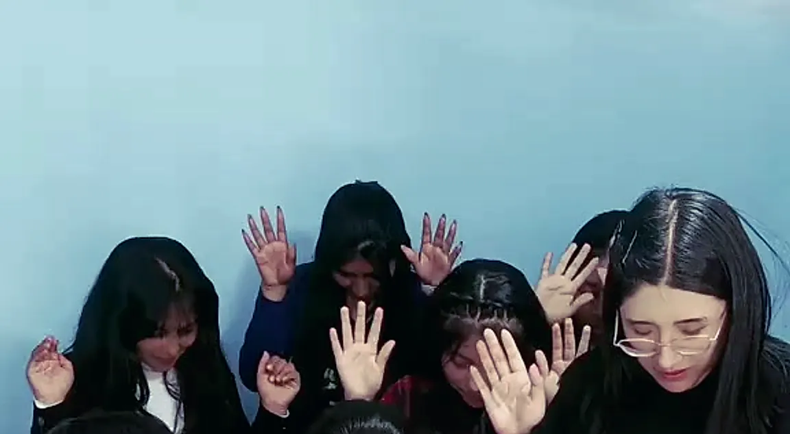Jóvenes orando con las manos alzadas